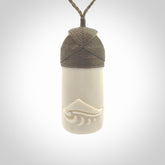 A hand carved bone toki with NZ Pacific logo engraving. Unique hand made jewellery from New Zealand Pacific.